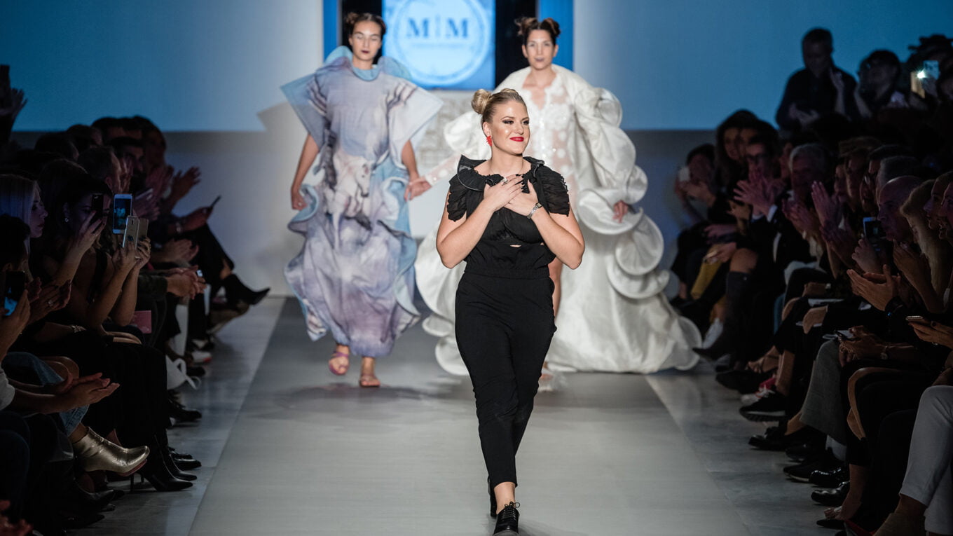 a woman walking on a fashion show
